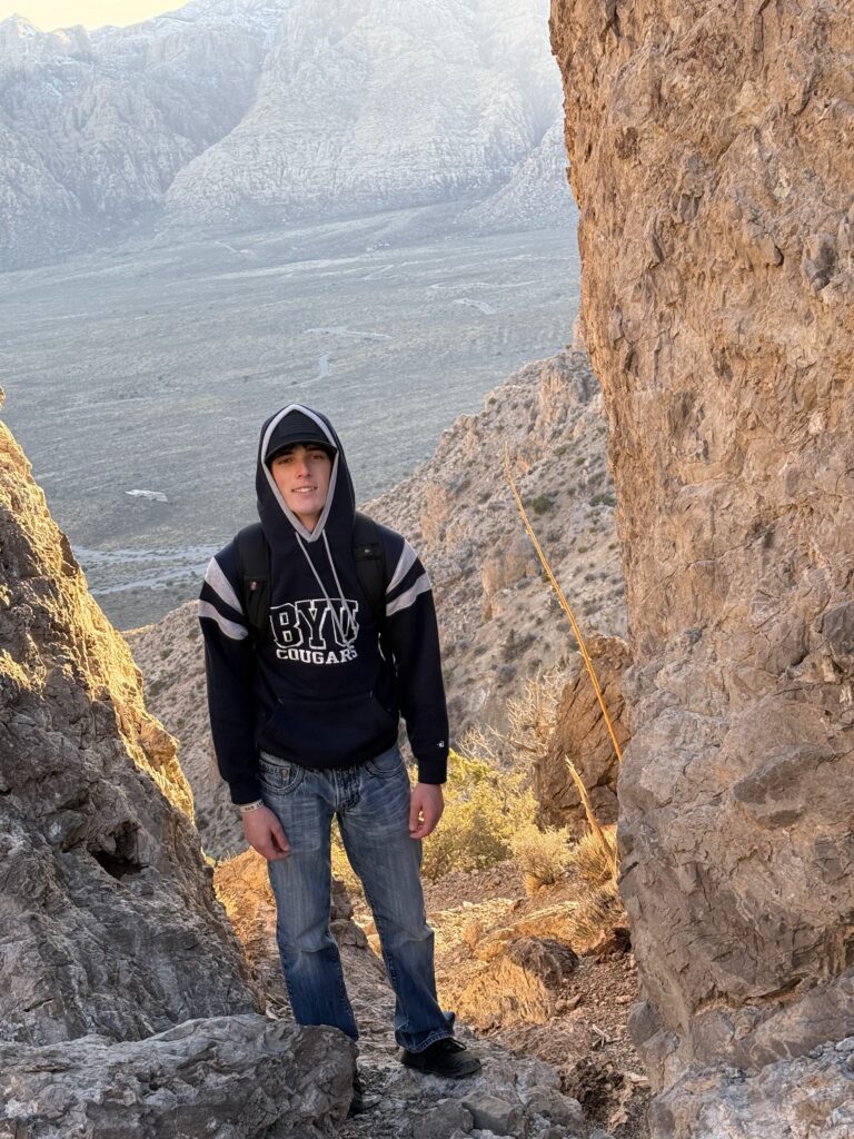Elias exploring a rocky canyon wearing BYU hoodie